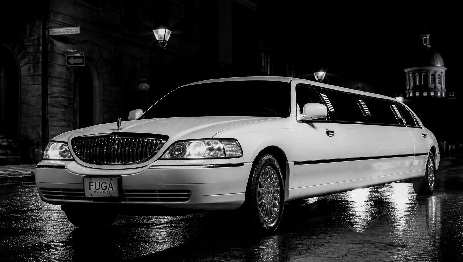 Limousine Lincoln Town Car blanche stationnée la nuit dans le Vieux-Montréal